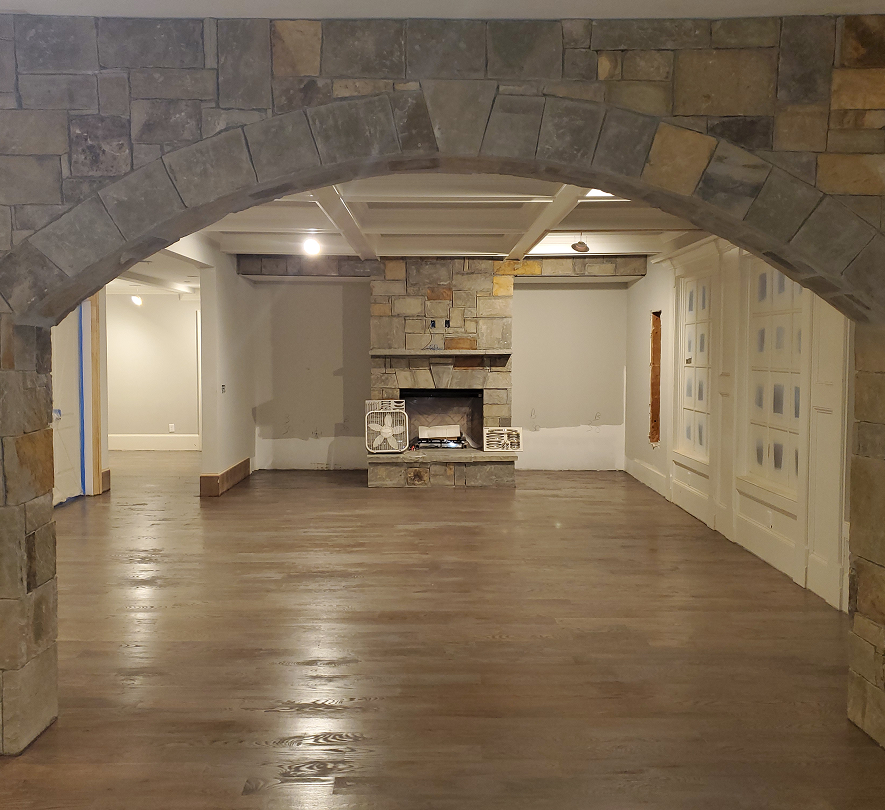 Cozy room with stone fireplace and archway.