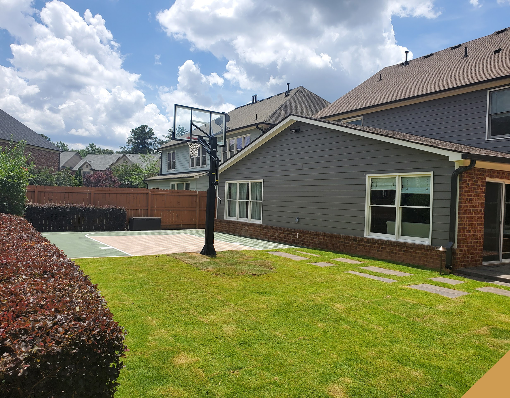 Residential backyard featuring basketball court.