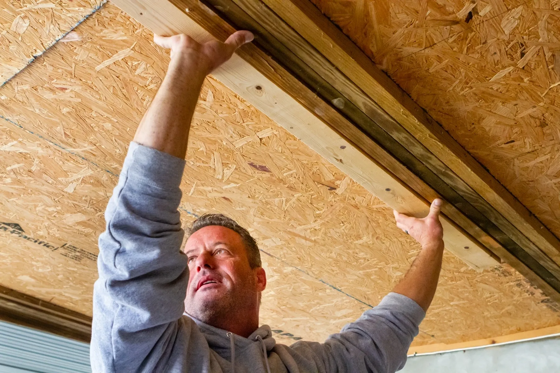 Worker adjusting overhead wood panel